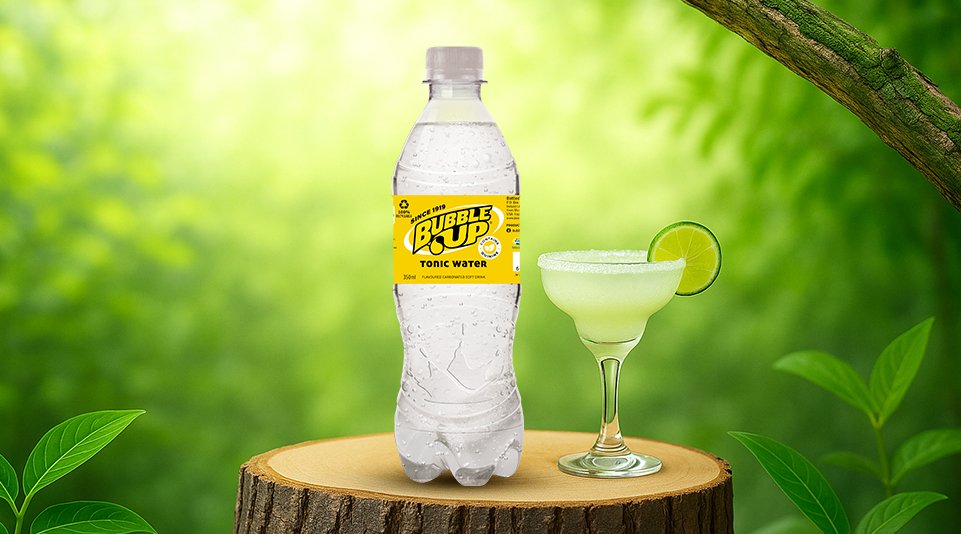 Bubble Up tonic water bottle with lime cocktail on wooden surface